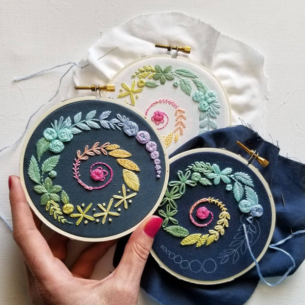 Jessica Long Spiral Sampler beginner embroidery kit on navy fabric. Learn 14 essential embroidery stitches with step-by-step video guidance. Includes printed navy fabric, 10 cm (4") hoop, DMC thread & instructions.