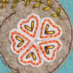 Embroidered floral on felt with orange and gold DMC thread. By Corinne Lapierre. Available at tinypatio.com