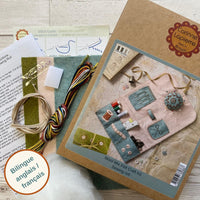 Wool mix felt craft kit with materials and packaging on a wooden surface. Designed by Corinne Lapierre. Available at tinypatio.com