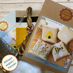 Embroidery kit with linen lavender bags featuring bee designs, Corinne Lapierre branding, and a bilingue label.