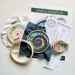 Jessica Long Beginner Embroidery kit with completed pieces, fabric, and instructions on a light surface