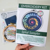 Embroidery kit with spiral sampler design, including hoop, floss, and instructions.