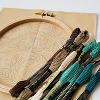  A picture of 7 full skeins of DMC thread with other supplies inWinter Birds Embroidery Kit | Beginner Chain Stitch, 6-inch by Jessica Long