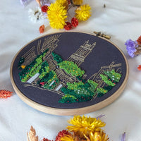 The finished Circus Lane hoop laid flat on white, surrounded by dried yellow and purple flowers