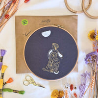 Paraffle kraft kit envelope with the completed hare hoop on top, DMC threads and gold scissors laid around it