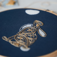 The hare hoop photographed close and slightly angled, showing the raised gold stitching