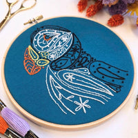 The puffin hoop tilted to show the raised white paisley stitching across the bird's body