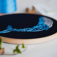 The whale hoop tilted to show the raised paisley stitching across its tail and fins
